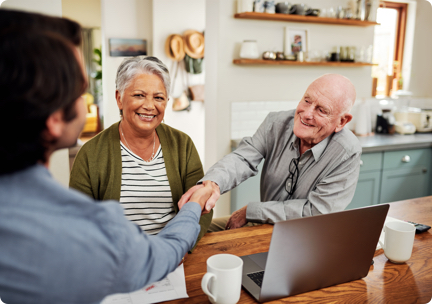 Man meeting with couple in kitchen, shaking hands